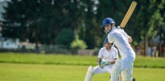 The Gentleman’s Game: Exploring the Traditions and Etiquette of Cricket Male batsman hitting cricket ball while wicket-keeper standing behind stumps on the pitch.